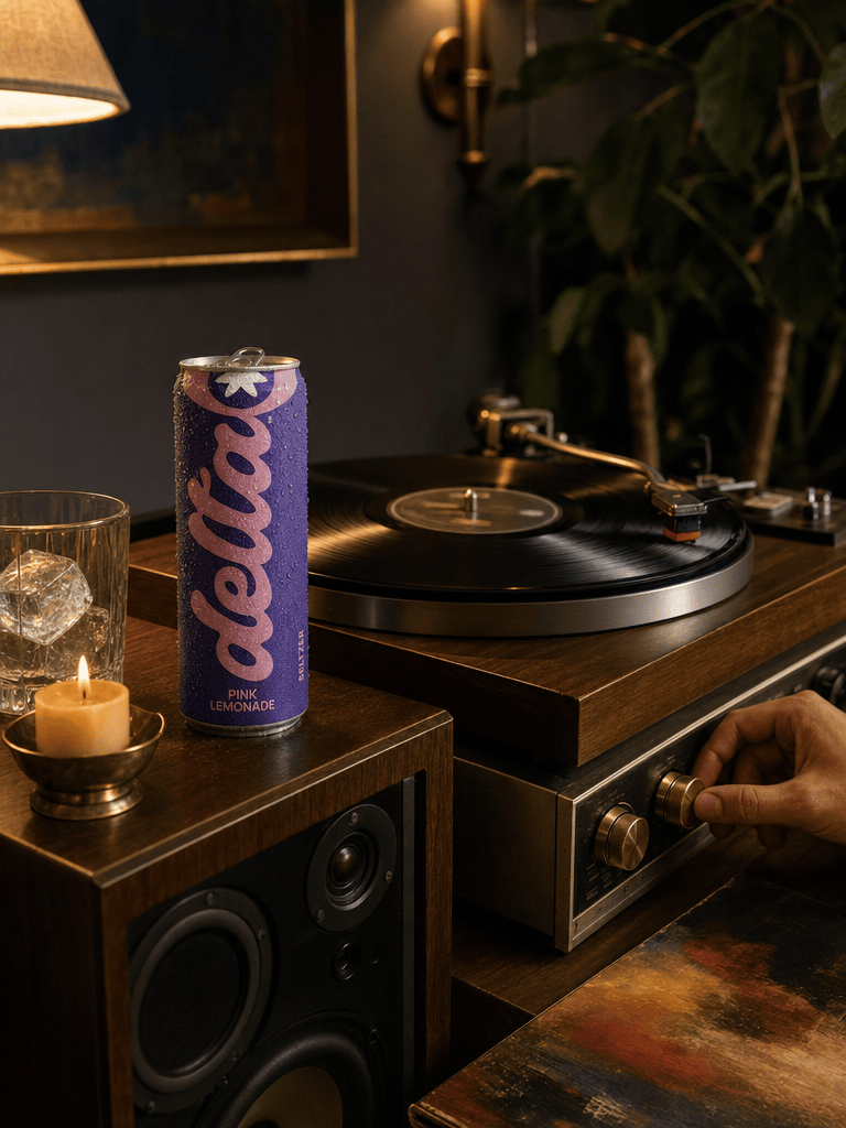 Vinyl record spinning on a wood-and-brass turntable, a 20mg Pink Lemonade can on the speaker, dim warm lamp